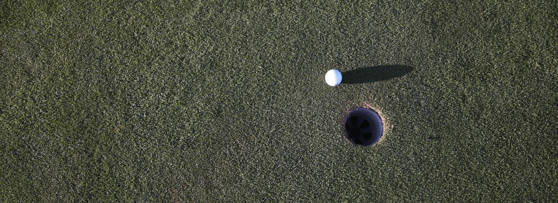 aerial view of golf ball near hole